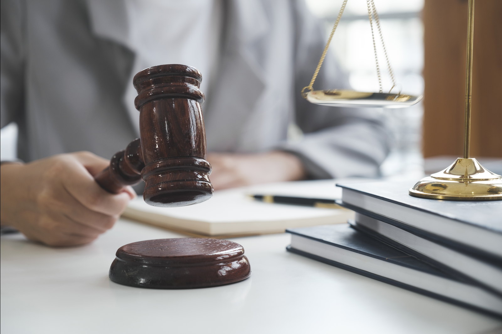 A judge bringing down a gavel beside the scales of justice